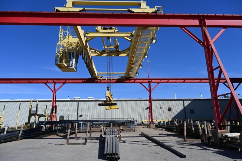 A foto mostra uma área externa industrial com estruturas metálicas robustas.