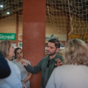 Foto mostra o vice-governador Gabriel Souza gesticulando enquanto conversa com membros da comunidade escolar de Independência, durante visita ao município.