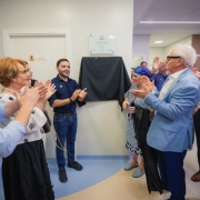 Vice-governador Gabriel Souza e secret&aacute;ria Arita Bergmann em frente a placa com outras autoridades. Todos batem palmas.